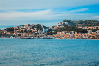 Scenic view of sea by buildings against sky