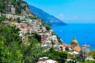 High angle view of townscape by sea against sky