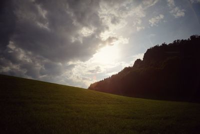 Scenic view of grassy field against cloudy sky