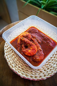 Malaysian or indonesian food sambal prawn. shrimps or prawn spicy taste in a takeaway container.