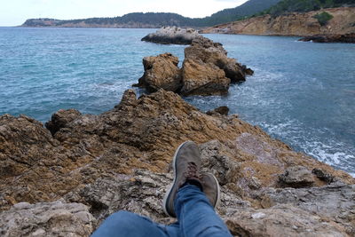 Low section of person on rock at beach