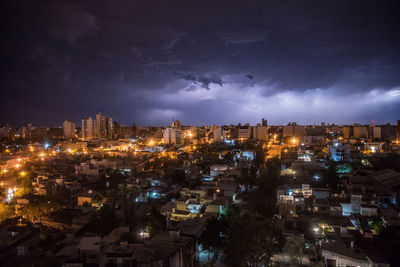 High angle view of illuminated buildings against sky at night