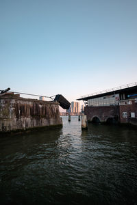 View of bridge over river against clear blue sky