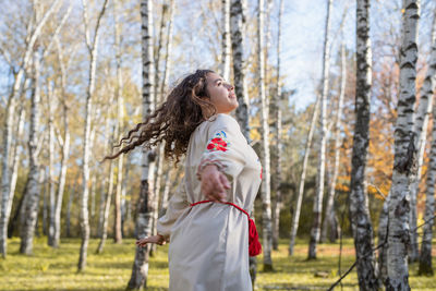  beautiful woman in national ukrainian national traditional costume clothes dancing in forest