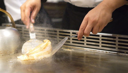 Midsection of chef preparing food at restaurant