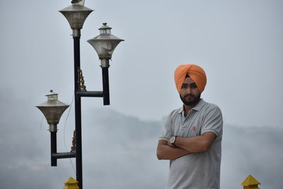 Portrait of man wearing turban while standing by street light