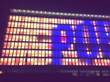 Low angle view of illuminated building against blue sky