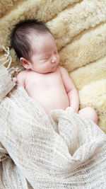 High angle view of naked baby girl sleeping on bed