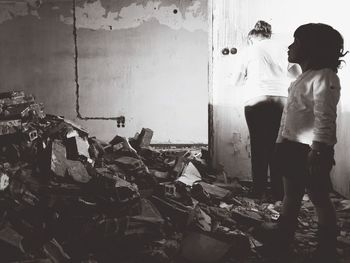 Rear view of people standing against wall