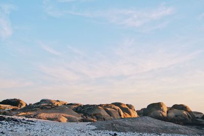 Rock formations by sea against sky