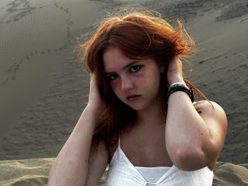 Portrait of young woman standing at beach