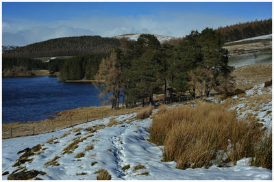 Scenic view of lake against sky during winter