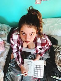 Portrait of young woman lying on bed at home