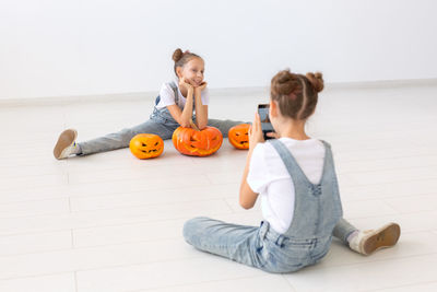 Sister photographing girl at home