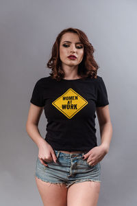 Portrait of beautiful young woman against gray background