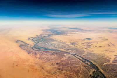 Aerial view of desert and river against sky