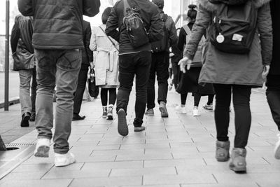 Low section of people walking on zebra crossing