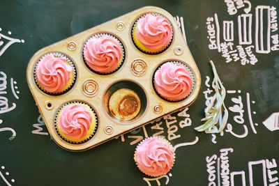 High angle view of cupcakes in baking pan on chalkboard