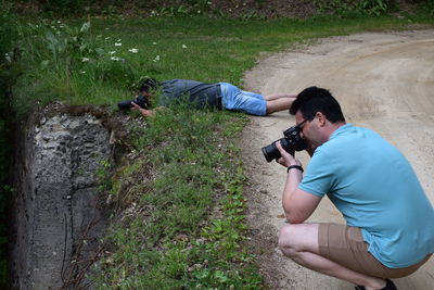 Men photographing on dirt road