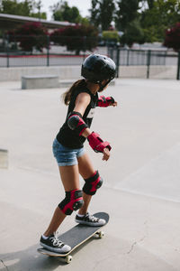 Side view of girl skateboarding at park
