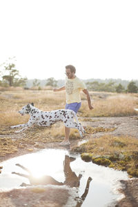 Young man running with dog, finland