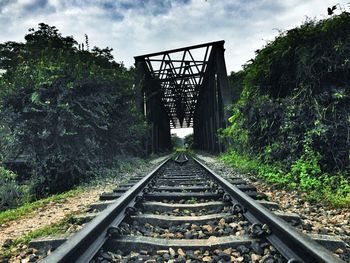 Railroad track against cloudy sky