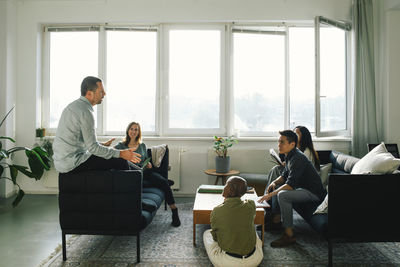 Multiracial business professionals discussing with each other in meeting at office