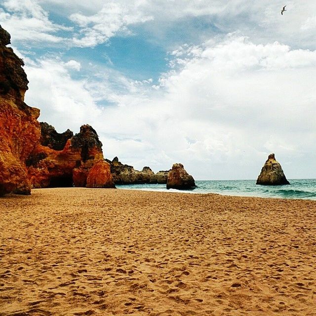 sea, beach, sand, water, sky, tranquil scene, scenics, tranquility, horizon over water, shore, beauty in nature, nature, coastline, cloud, cloud - sky, rock formation, idyllic, vacations, incidental people, rock - object