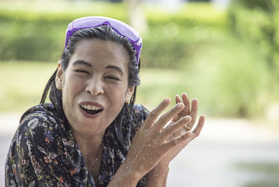 Portrait of smiling woman amidst splashing water