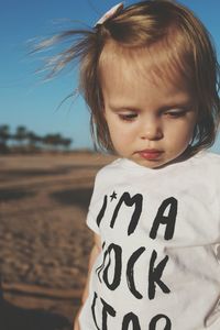 Close-up of cute girl against sky