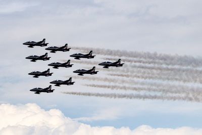 Low angle view of airplanes flying against sky