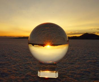 Close-up of crystal ball against sky during sunset