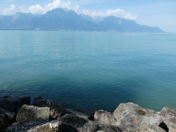 Scenic view of sea and mountains against sky