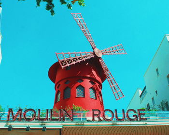 Low angle view of traditional windmill against clear blue sky