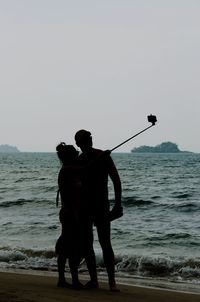 View of sea with arms outstretched in background