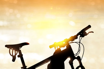 Silhouette bicycle against sky during sunset