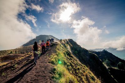 People walking on mountain against sky