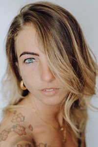 Close-up of beautiful young woman against white background