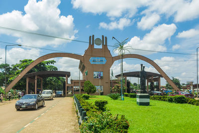 Road by buildings against sky in city