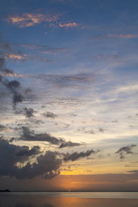 Scenic view of sea against dramatic sky during sunset