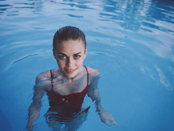 Portrait of young woman swimming in pool