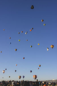 Low angle view of hot air balloons against blue sky