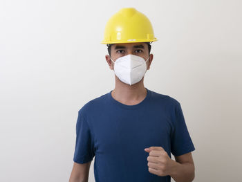 Portrait of young man standing against white background