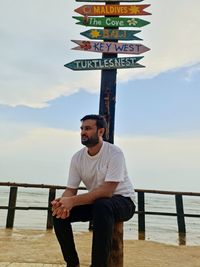 Portrait of young man standing against sky