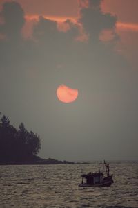 Boats in sea at sunset