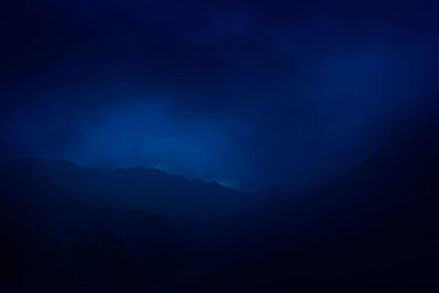 Scenic view of silhouette mountain against sky at night