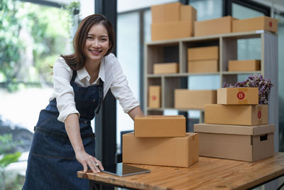 Portrait of young woman standing in cardboard box