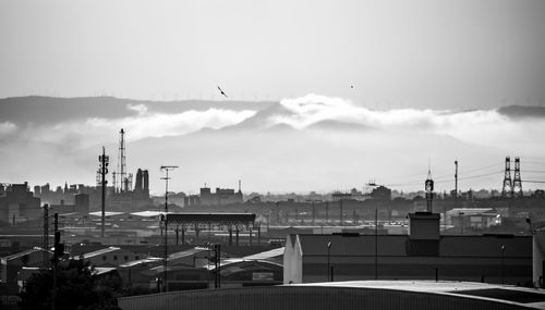 View of buildings in city against cloudy sky