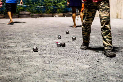 Low section of people playing with ball on street