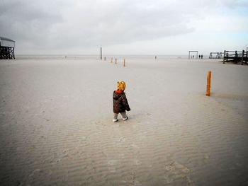 Full length of boy on beach against sky